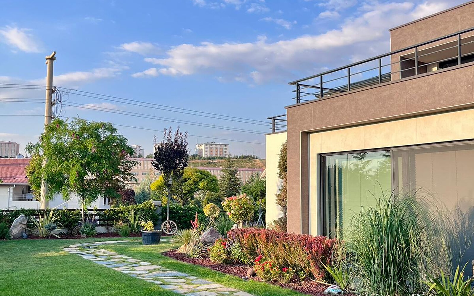 Eksen Peyzaj tarafından düzenlenmiş villa bahçesi — çim alan, doğal taş yürüyüş yolu ve bitkilendirme